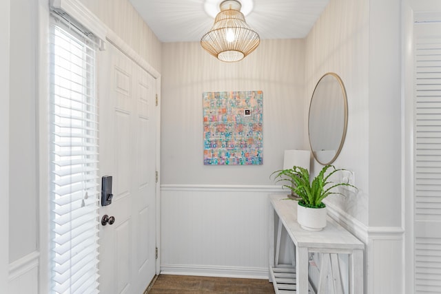 entryway with dark wood-style flooring and wainscoting