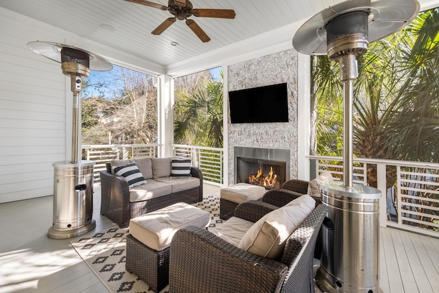 deck with an outdoor living space with a fireplace