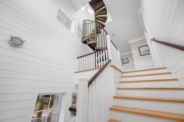 staircase with a high ceiling and ornamental molding