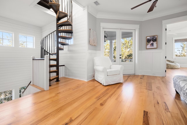 living area with ceiling fan, plenty of natural light, hardwood / wood-style floors, and ornamental molding