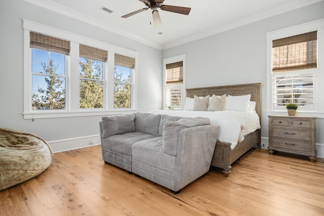 bedroom with ceiling fan, crown molding, and light hardwood / wood-style flooring