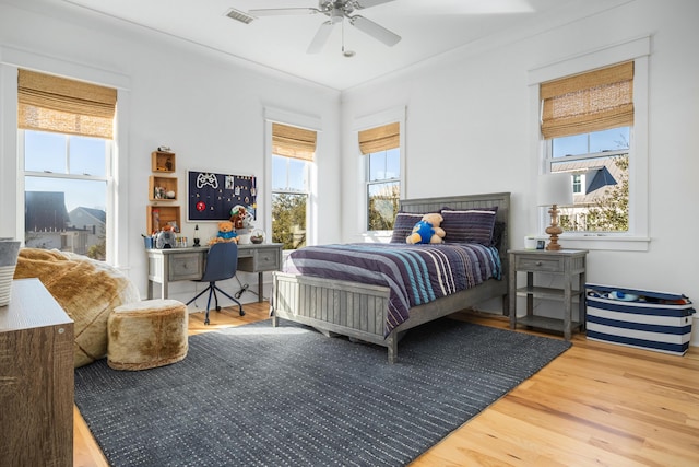 bedroom with ceiling fan, wood-type flooring, and ornamental molding