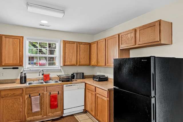 2919 Fernwood Dr, North Charleston, SC 29406 - kitchen with dishwasher, a sink, light countertops, light tile patterned floors, and freestanding refrigerator