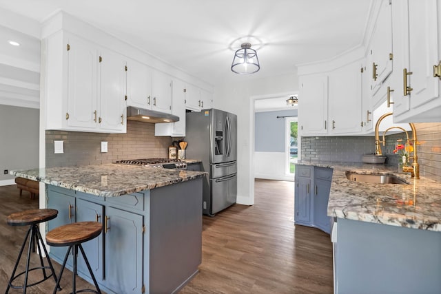 1468 N Relyea Ave, Charleston, SC 29412 - kitchen with stainless steel fridge, under cabinet range hood, a peninsula, dark wood finished floors, and white cabinets
