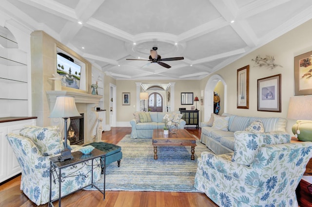 living room featuring beamed ceiling, a fireplace, and coffered ceiling