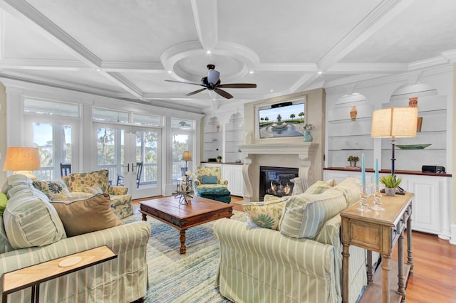 living room with coffered ceiling, crown molding, ceiling fan, built in features, and beam ceiling