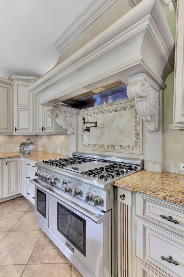 kitchen featuring light tile patterned floors, tasteful backsplash, range with two ovens, and ornamental molding