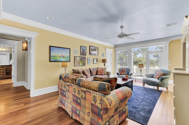 living room featuring light hardwood / wood-style flooring, ceiling fan, and ornamental molding