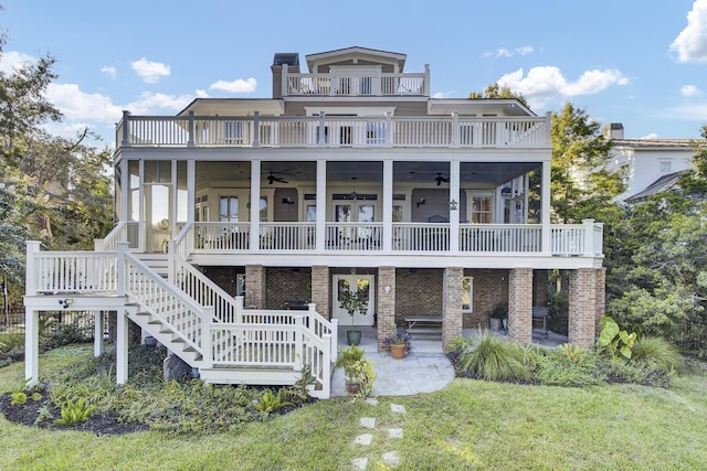 back of property featuring ceiling fan, a patio area, a balcony, and a yard