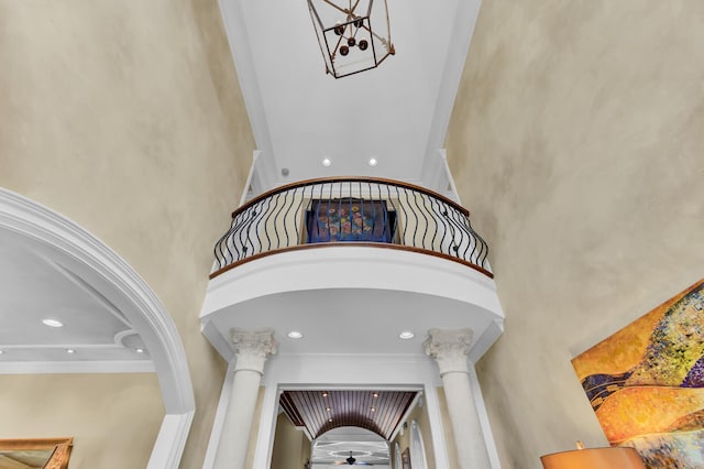 stairway featuring a high ceiling and decorative columns