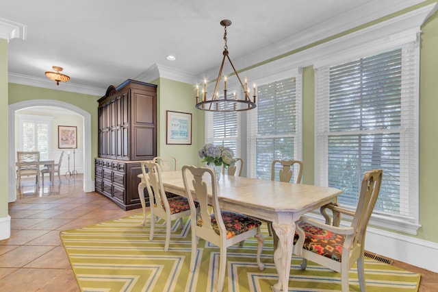 dining room featuring light tile patterned floors, an inviting chandelier, and ornamental molding