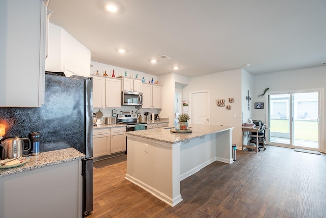 kitchen featuring light stone counters, white cabinets, a kitchen island, stainless steel appliances, and dark hardwood / wood-style flooring