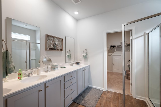 bathroom with vanity, a shower with door, and hardwood / wood-style flooring