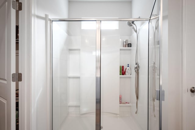 bathroom featuring a shower with door