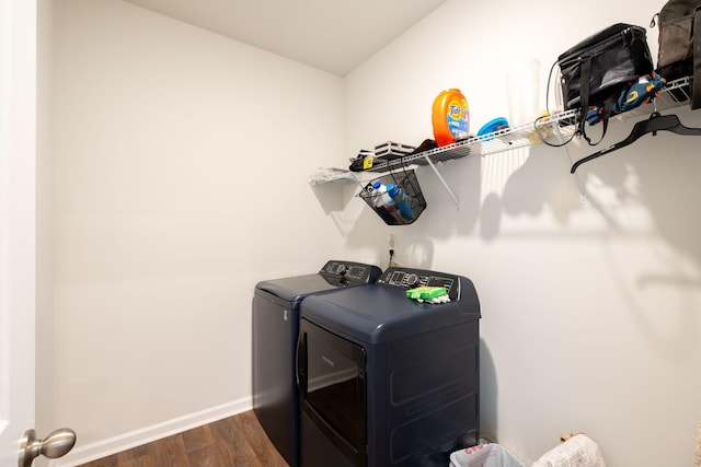 washroom with dark wood-type flooring and washing machine and dryer