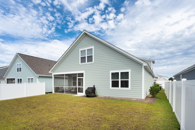 back of property featuring a sunroom and a lawn