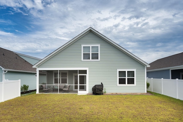 back of property featuring a sunroom and a yard