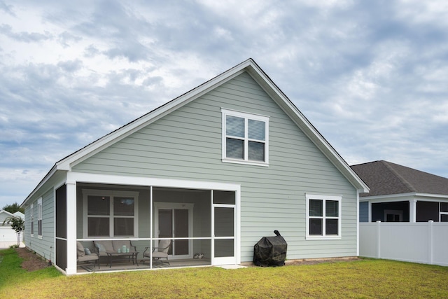 rear view of house featuring a sunroom, a patio area, and a yard