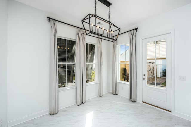 unfurnished dining area featuring plenty of natural light and a notable chandelier