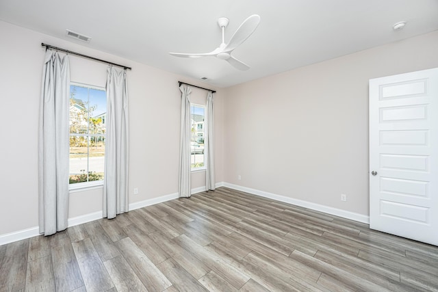 unfurnished room featuring a wealth of natural light, ceiling fan, and light wood-type flooring