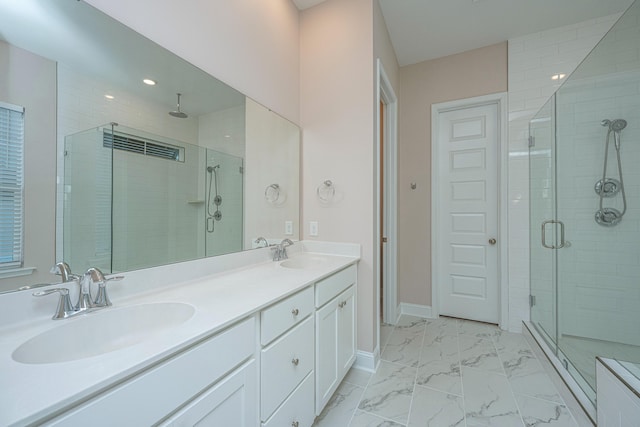 bathroom with vanity and a shower with door