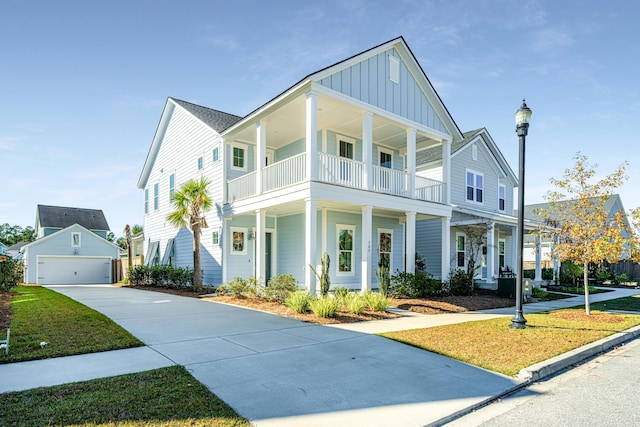 view of front of house featuring a garage, a balcony, an outdoor structure, and a front yard