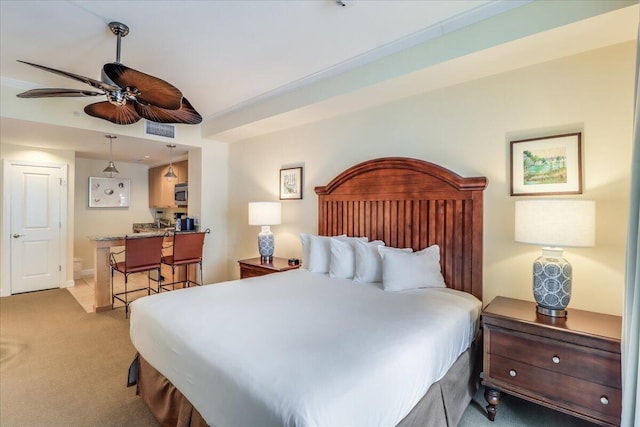 carpeted bedroom featuring ceiling fan and ensuite bath