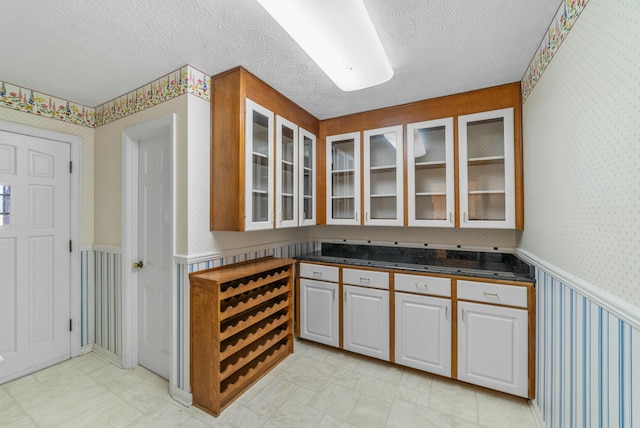 kitchen with white cabinets and a textured ceiling