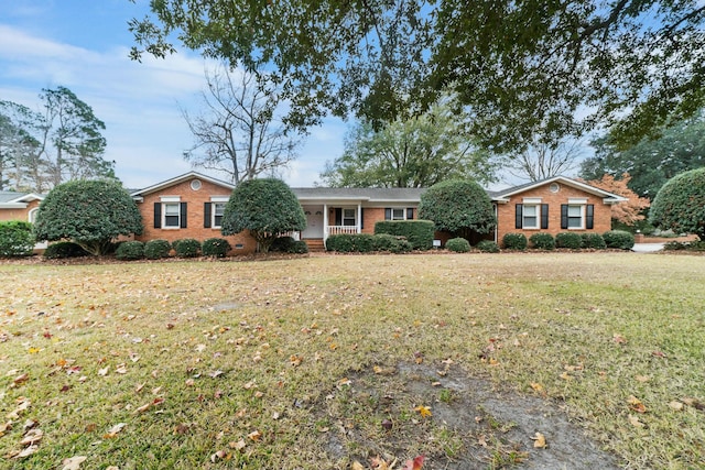 ranch-style house with a porch and a front lawn