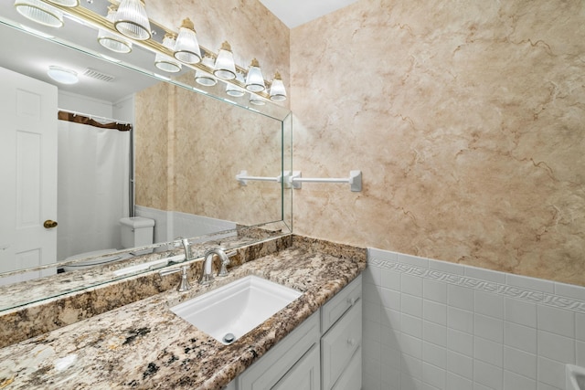 bathroom with vanity and tile walls