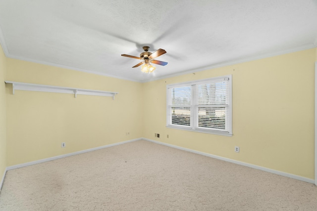 carpeted empty room with ceiling fan and ornamental molding