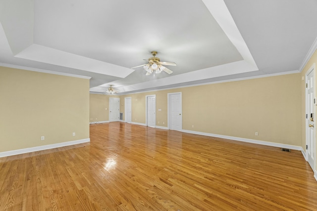 unfurnished living room with ceiling fan, crown molding, light hardwood / wood-style flooring, and a tray ceiling