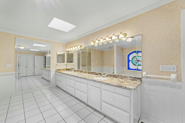 bathroom featuring tile patterned floors, vanity, crown molding, and a skylight