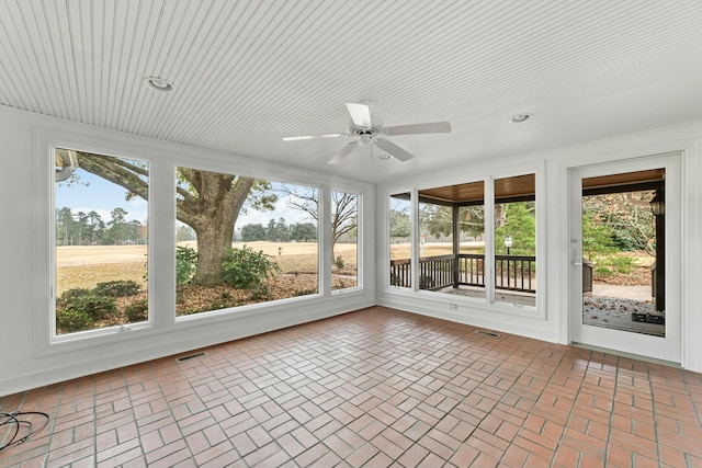 unfurnished sunroom with a wealth of natural light and ceiling fan