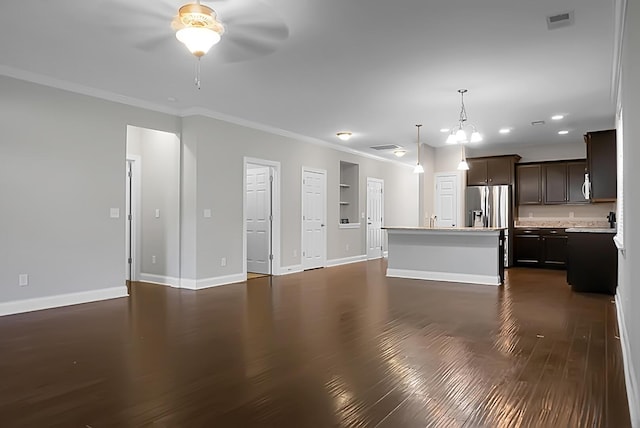 unfurnished living room with visible vents, baseboards, dark wood-style flooring, a ceiling fan, and crown molding