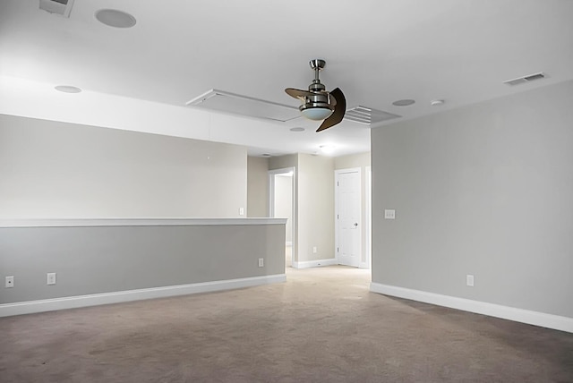 carpeted empty room with visible vents, baseboards, attic access, and ceiling fan