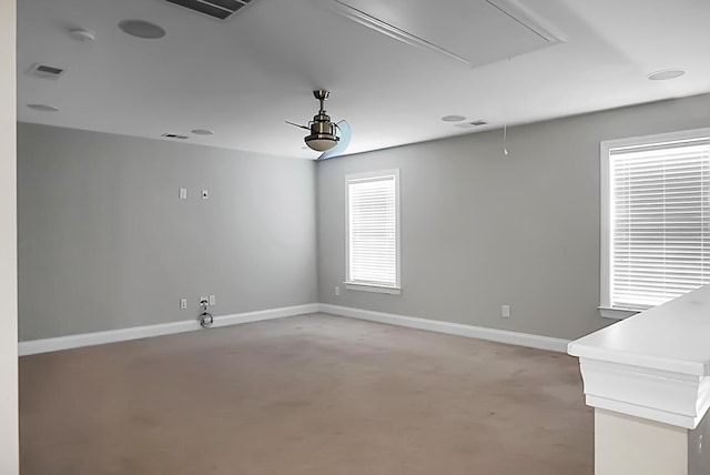 unfurnished room with attic access, baseboards, and visible vents