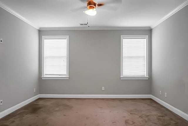 carpeted spare room featuring ornamental molding, baseboards, and visible vents