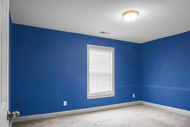 carpeted empty room featuring plenty of natural light, visible vents, and baseboards