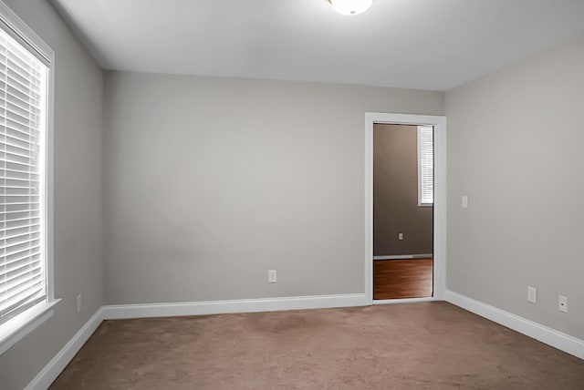 carpeted spare room featuring baseboards