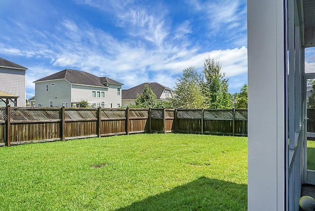 view of yard featuring a fenced backyard and a residential view