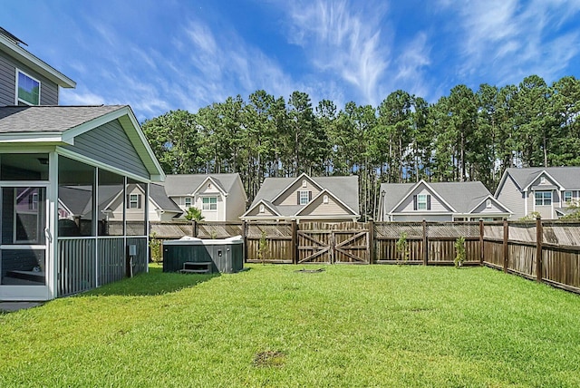 view of yard featuring a sunroom, a fenced backyard, and a residential view