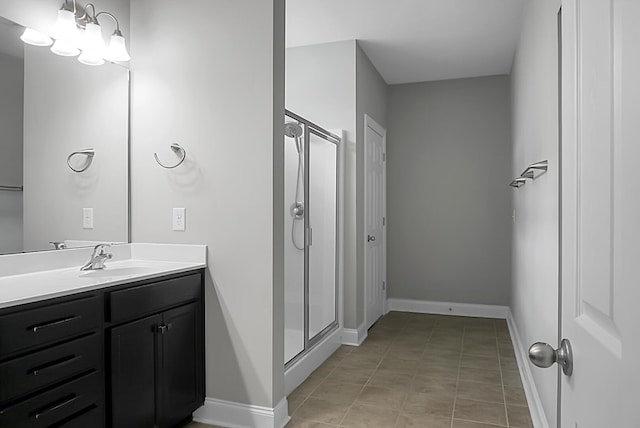 bathroom with a stall shower, vanity, and baseboards