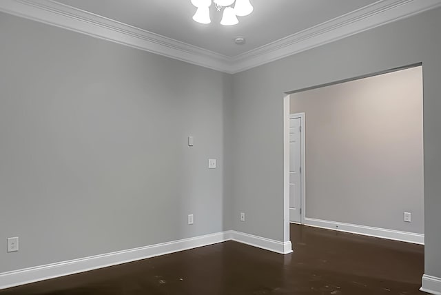 empty room featuring crown molding, baseboards, an inviting chandelier, and wood finished floors