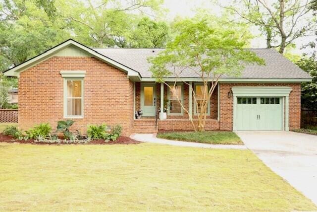 ranch-style house with brick siding, driveway, a front yard, and a garage