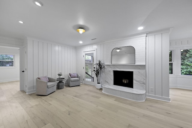 living area featuring recessed lighting, wood finished floors, and a premium fireplace
