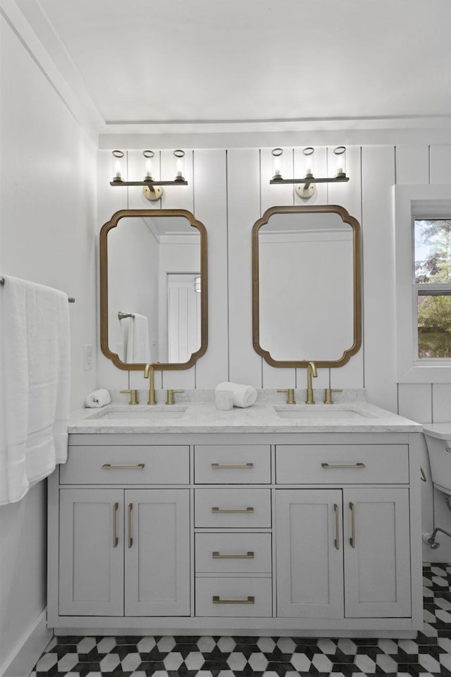 full bathroom with a sink, tile patterned floors, baseboards, and double vanity