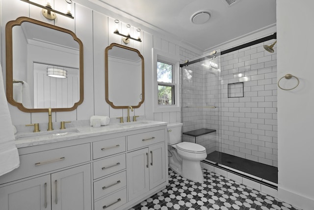 full bath with a sink, a stall shower, toilet, and double vanity