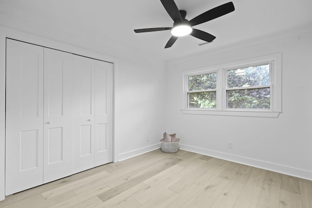 unfurnished bedroom with baseboards, light wood-style flooring, ceiling fan, and a closet