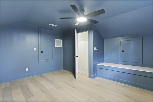 additional living space with ceiling fan, visible vents, vaulted ceiling, wood finished floors, and baseboards